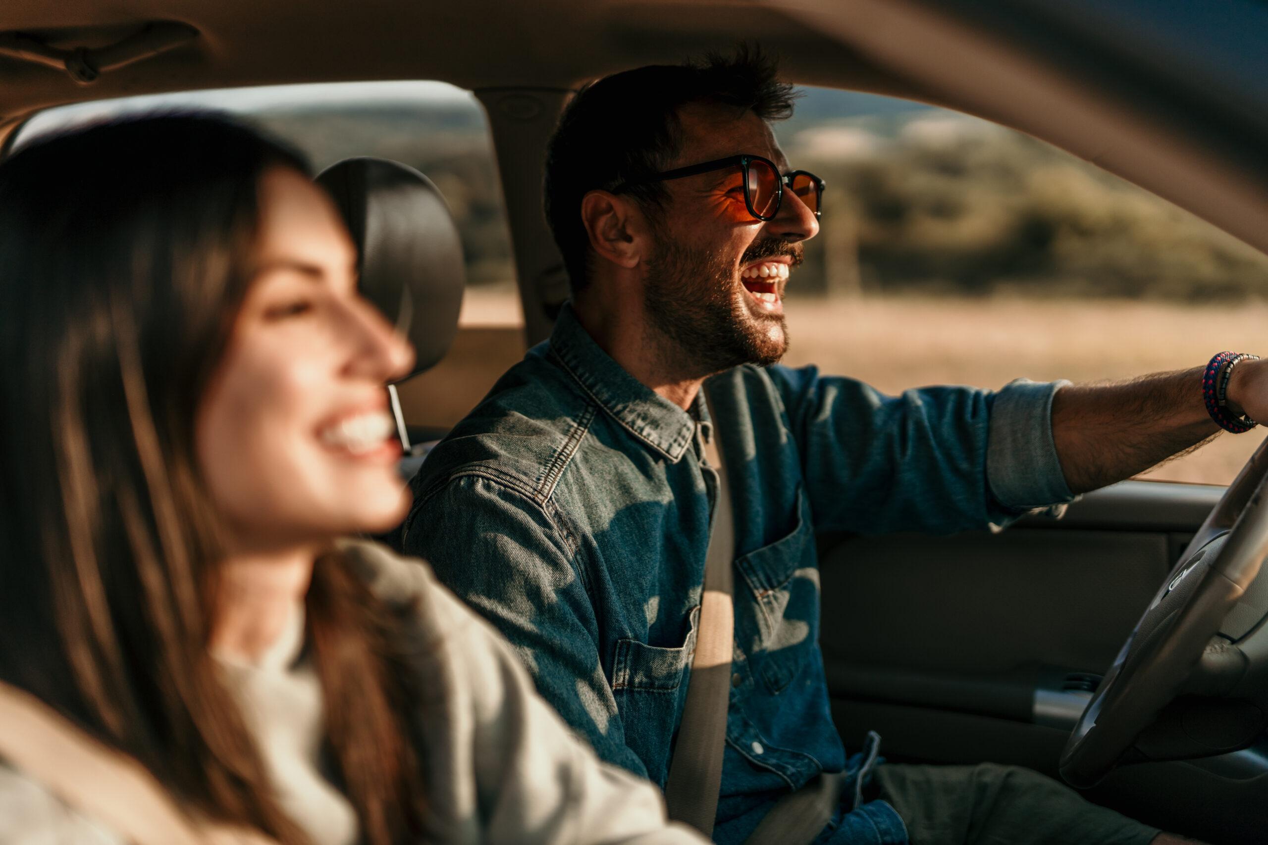 A couple driving a car in sunset
