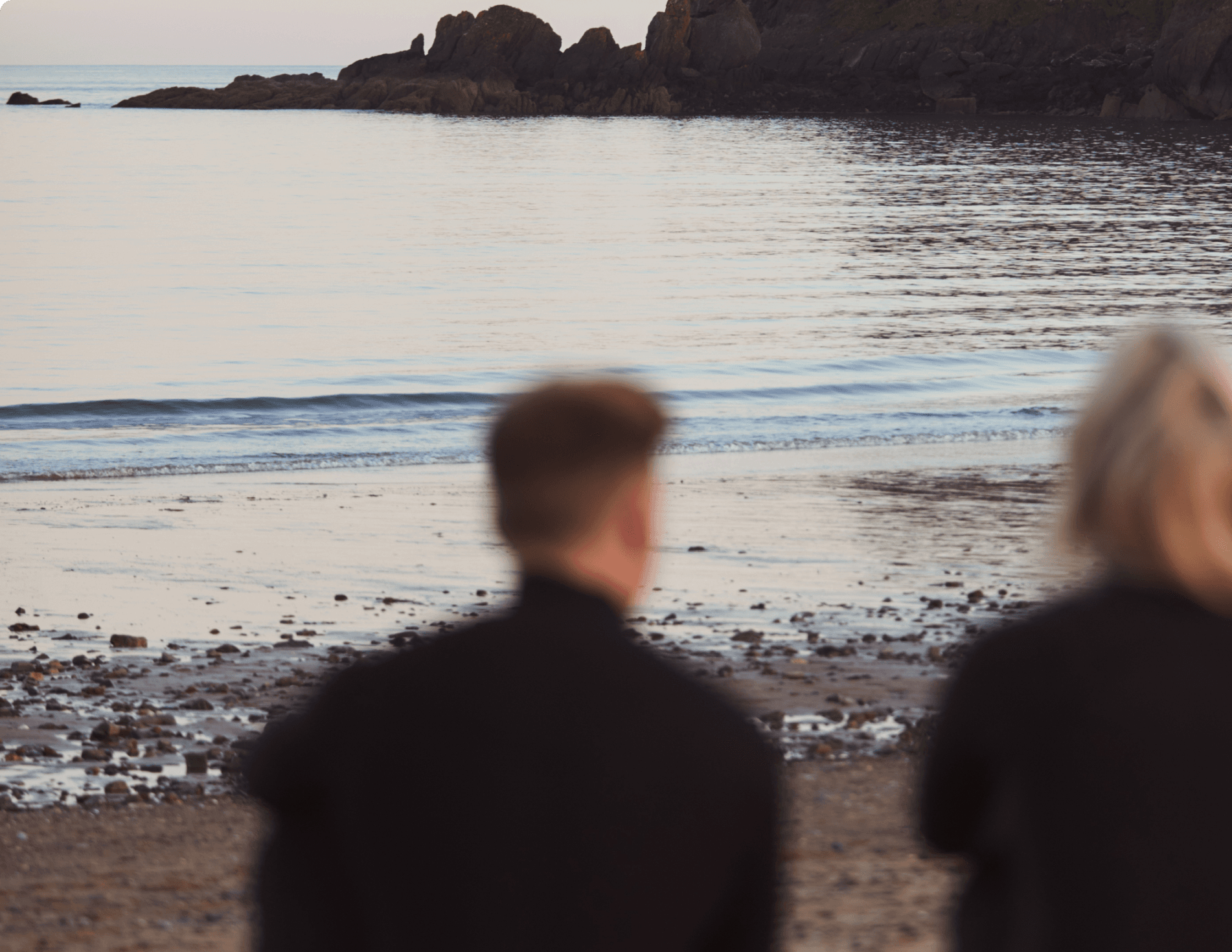 People overlooking the sea in sunset