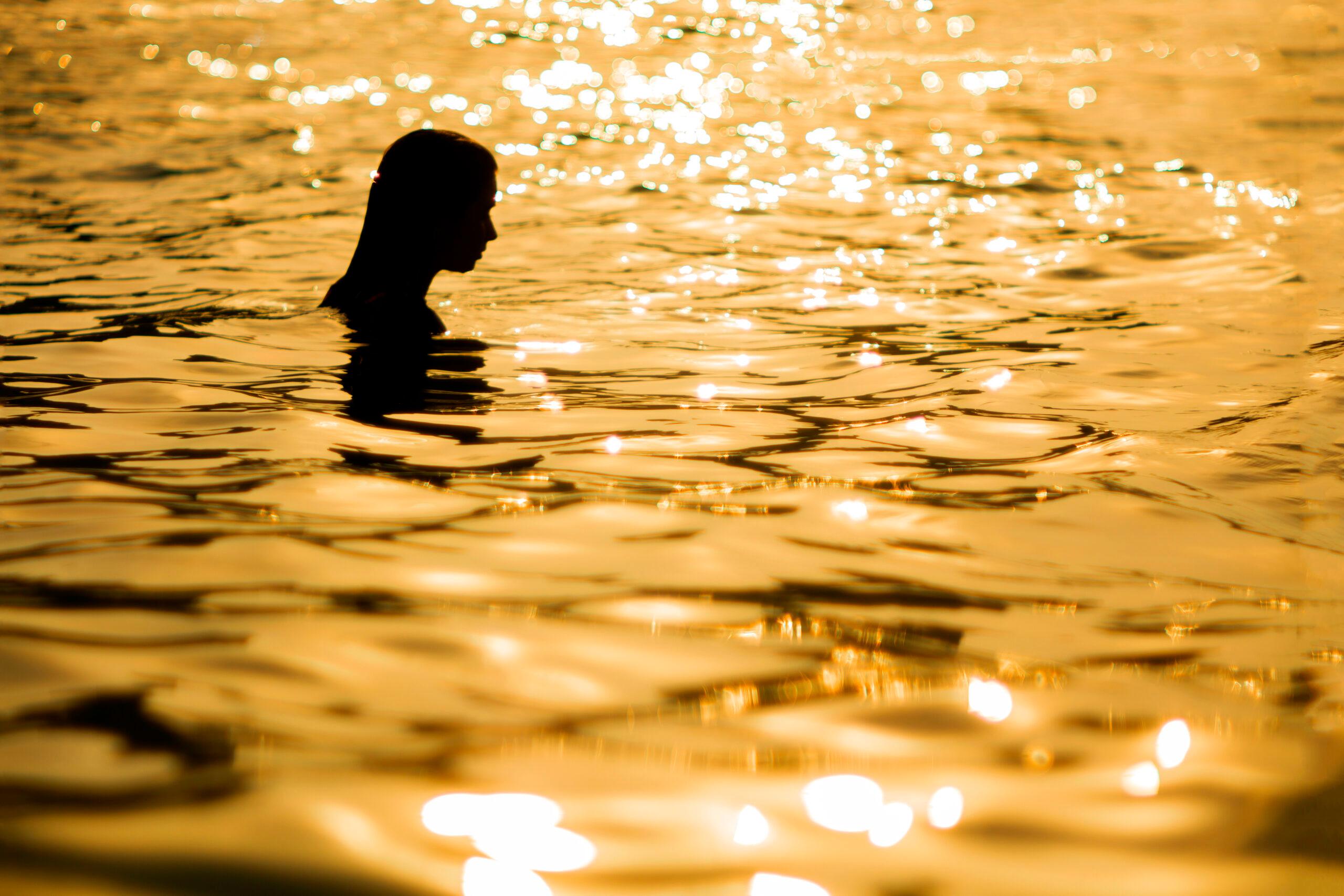 Woman swimming in sunset